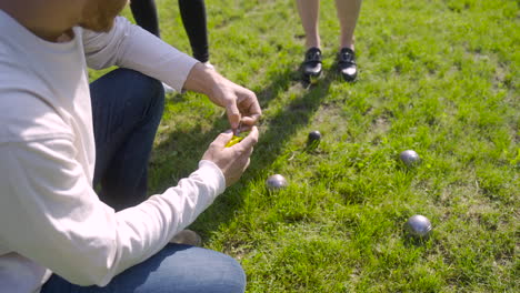 top view of a man calculating distance between petanque balls in the park