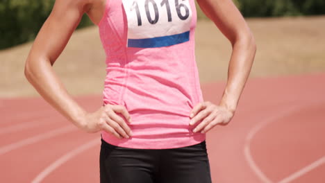 deportista con los brazos en las caderas de pie