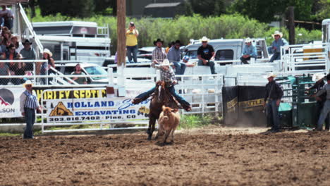 evergreen rodeo colorado mountain tradition professional cowboys cowgirl horse bull riding usa bucking tie down roping follow pan to the left american saddle fans crowd cheering event hot summer day