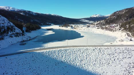 rotación aérea frente a la presa tunhovd - depósito de agua operado por statkraft para la central hidroeléctrica nore - invierno viendo tanto el vertedero de la presa como el agua en el interior - noruega