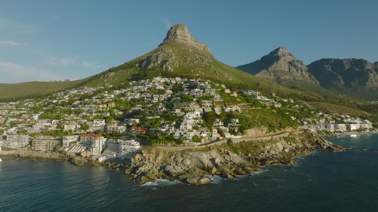 un barrio residencial de lujo bajo una alta montaña iluminado por el sol brillante. revelación al revés de la costa del mar. ciudad del cabo, sudáfrica