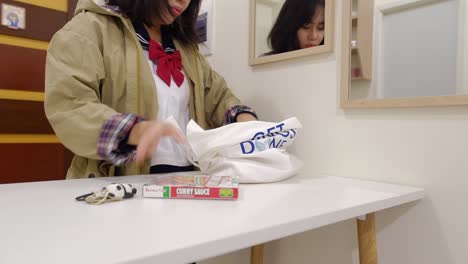 estudiante con abrigo llegando a casa y descargando comestibles de la bolsa