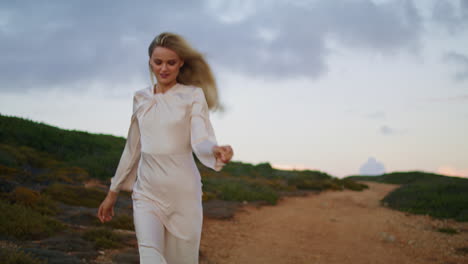 cheerful girl running hill vertical closeup. happy woman moving across sunset