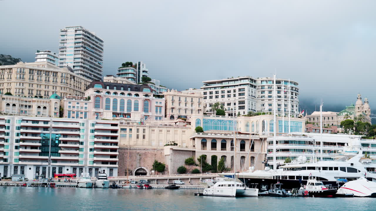 View of boats docked in the Monaco Marina with the skyline of the city on the background
