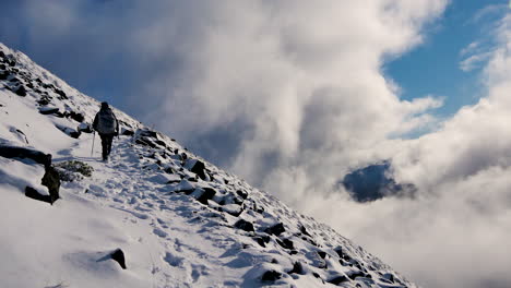 rear shot of person hiking on snowy mountain of kepler track in new zealand