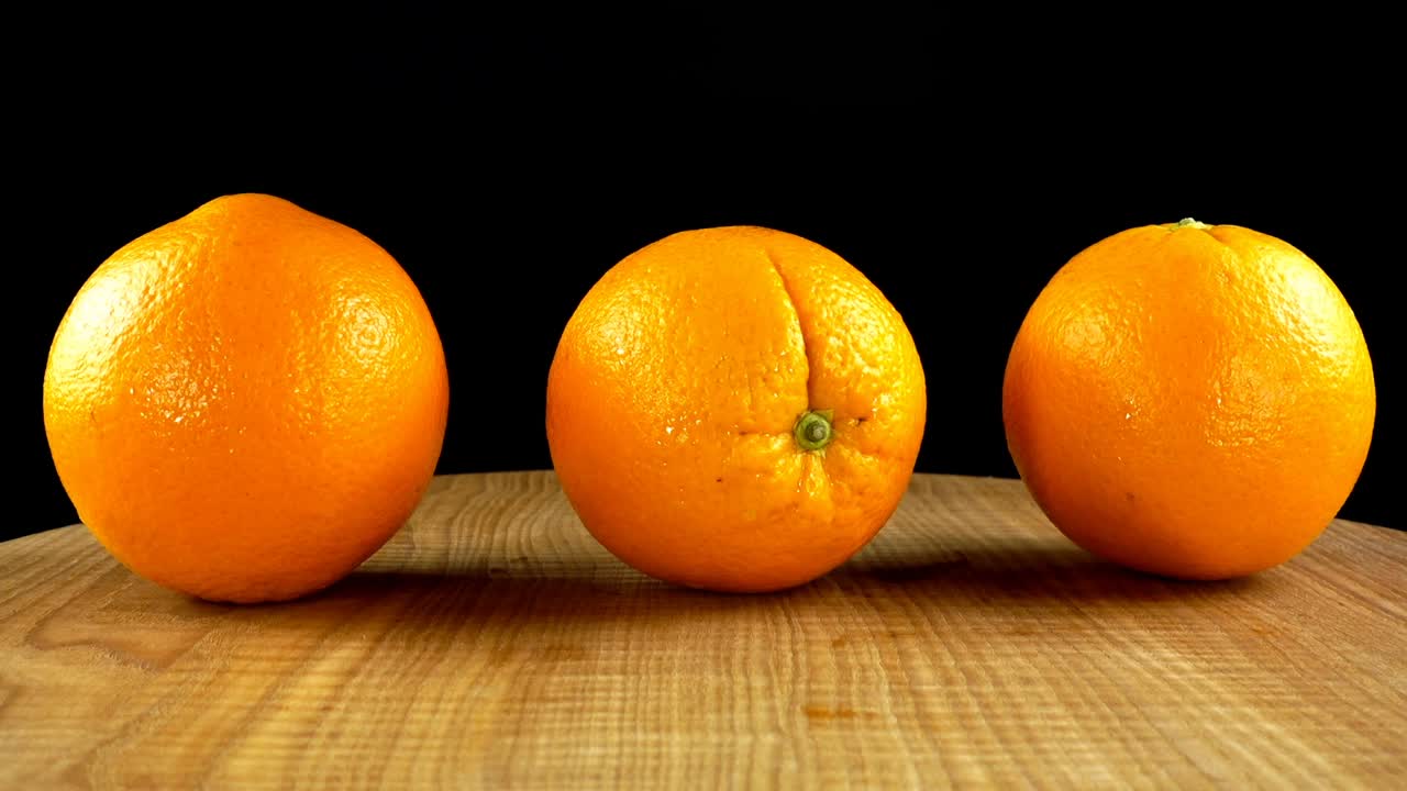 Orangen auf schwarzem Hintergrund. Schneidebrett in Bewegung