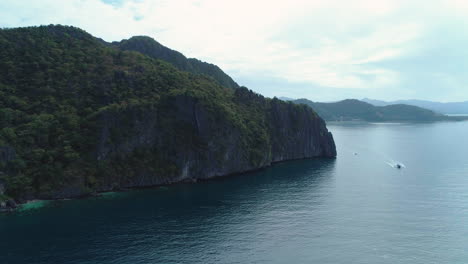 dramatic aerial orbit of rocky islands with green vegetation in palawan, philippines