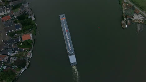 Aerial-shot-of-barge-sailing-down-the-river-in-town