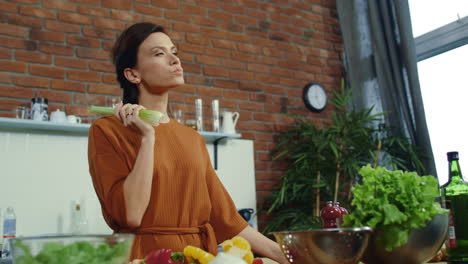 Niña-Comiendo-Apio-Fresco-En-Casa.-Mujer-Joven-Teniendo-Idea-Durante-La-Cocina.