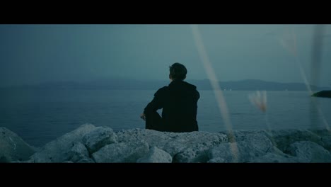 man contemplating the sea at dusk