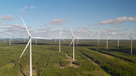 wind turbine farm panning shot landscape during a sunny day against a blue sky, aerial view