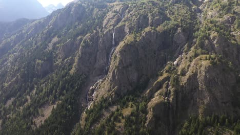 Toma-Aérea-Oscilante-De-Una-Hermosa-Cascada-Que-Sale-De-Una-Gran-Montaña-En-Francia