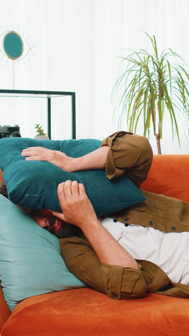 Los vecinos en el trabajo de reparación irritaron al hombre por la música fuerte en casa cubren las orejas con almohadas molestadas por el ruido
