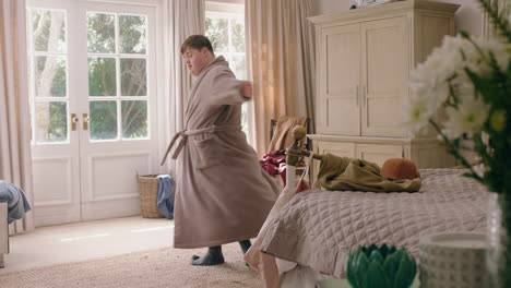 young teenage boy with down syndrome dancing in bedroom feeling happy having fun playful dance celebrating at home on weekend morning