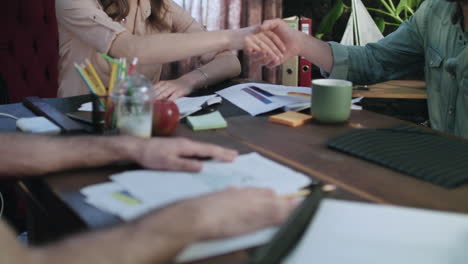 satisfied businesswoman shaking hands with business partner after negotiations