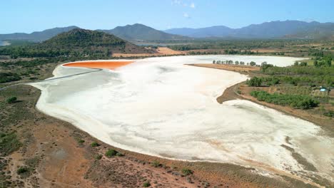 aerial images of a dry salt flat in sardinia italy mountain flamingos in the background