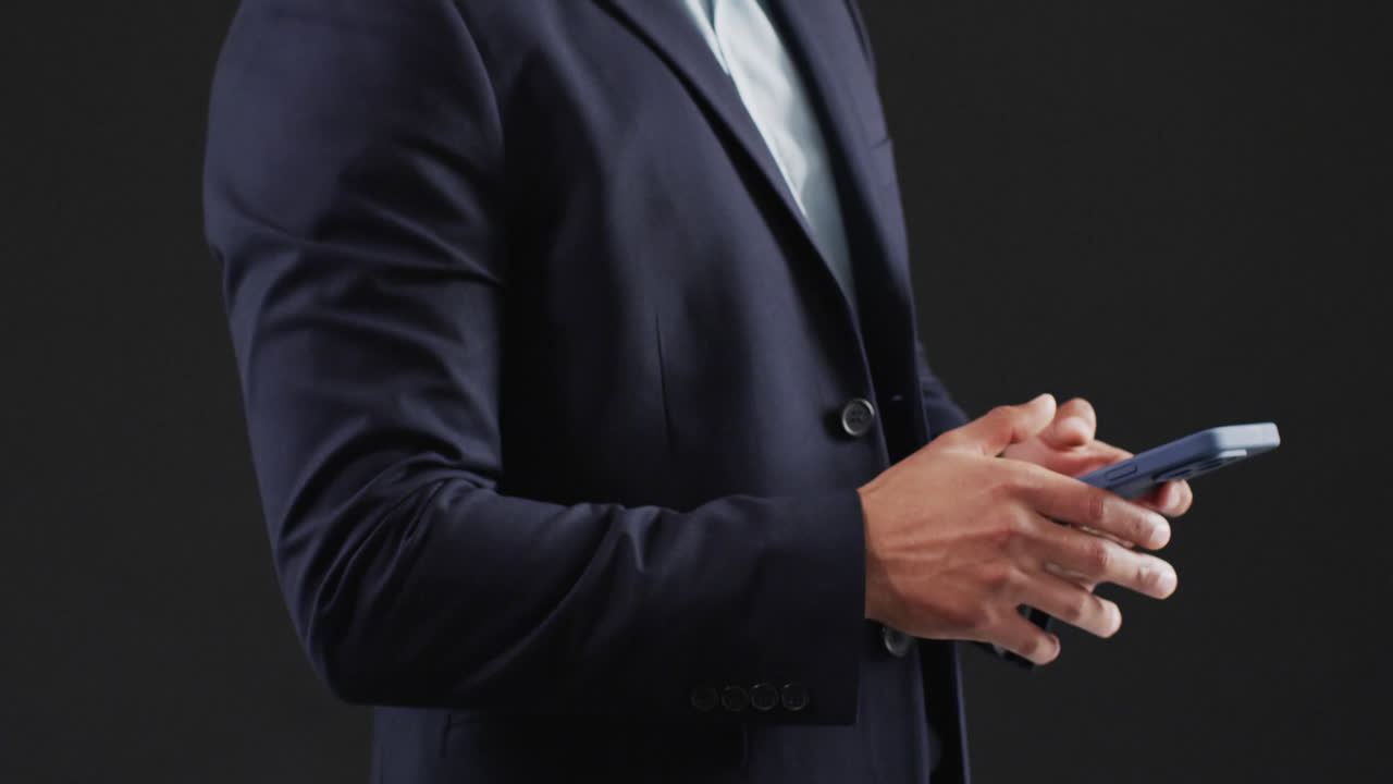 video de un hombre de negocios biracial con un teléfono inteligente y usando una pantalla holográfica, espacio de copia