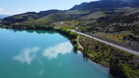 Drone-Alrededor-De-La-Carretera-Que-Bordea-El-Lago-Azul-De-Nueva-Zelanda