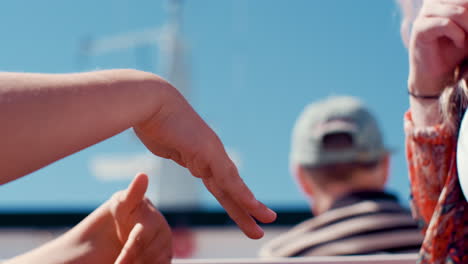 two young sisters playing the tickle game with their hands whilst going by ferry ship boat to a small island on vacation summer break on a sunny summers day spending quality time together having fun