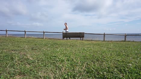 woman walking away from park bench with phone in hand