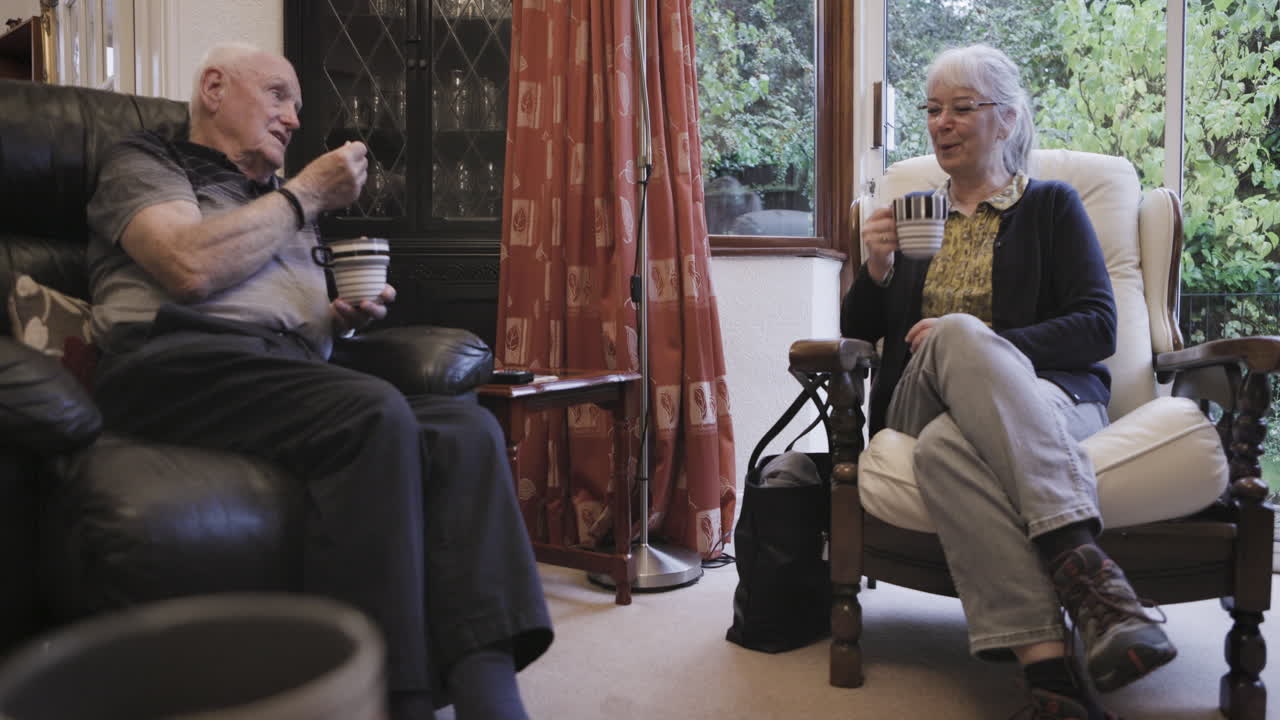 Elderly couple enjoying tea and conversation in their living room
