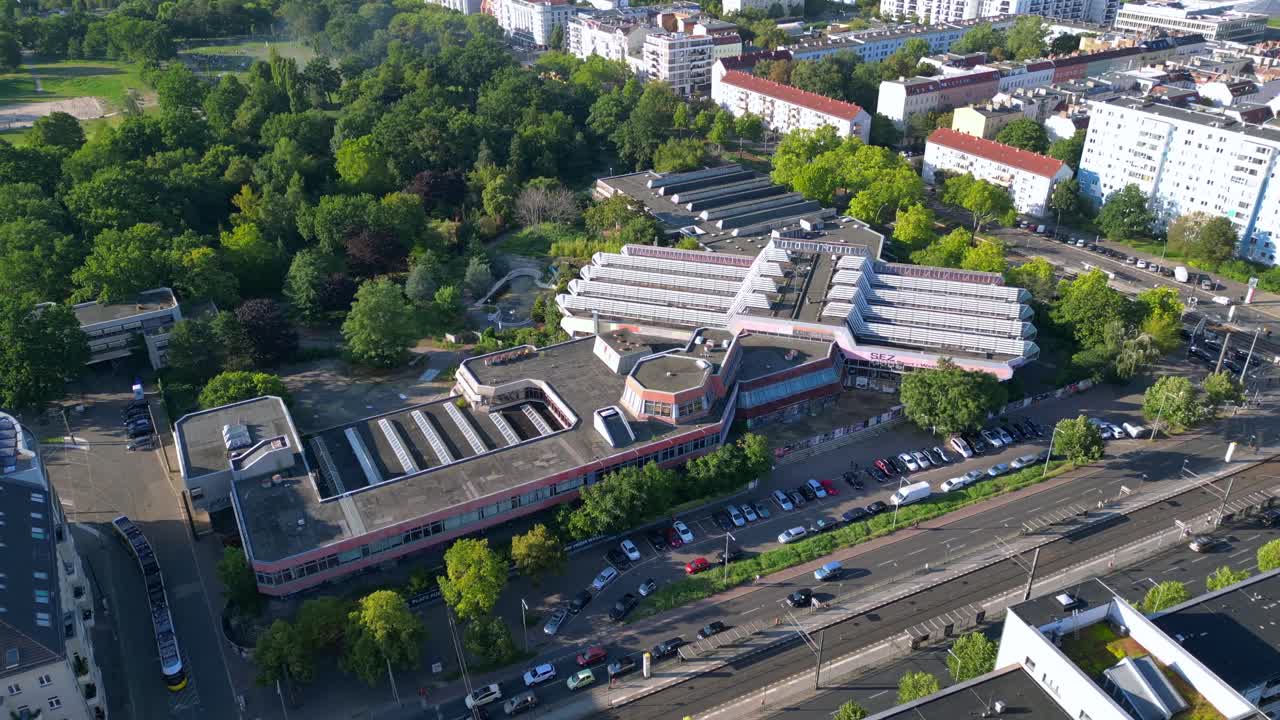 Sez and Volkspark Friedrichshain in Berlin, showcasing its lush greenery, a passing tram on a sunny day. speed ramp hyper motion time lapse Magic aerial view flight wide orbit overview drone