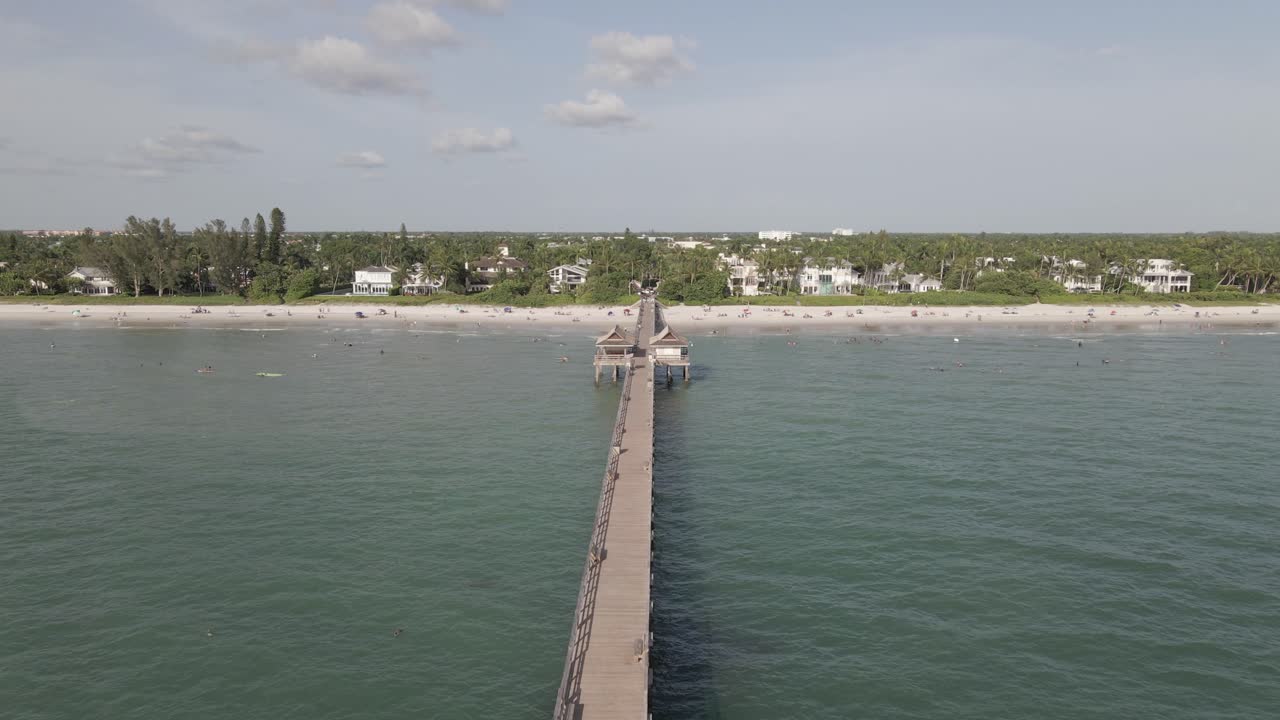 항공: 나폴리 낚시 부두는 따사로운 햇볕이 잘 드는 해변의 날에 거의 비어 있습니다.