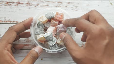 mano sosteniendo un recipiente de coloridas delicias turcas