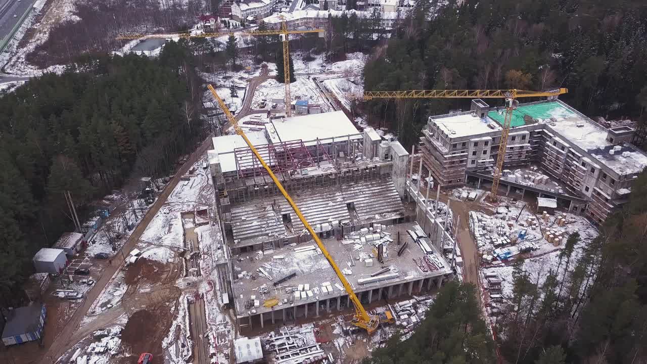 vista aérea de un sitio de construcción en invierno con un estadio en desarrollo
