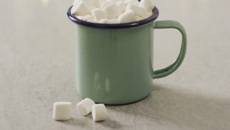 video of cup of hot chocolate with marshmallows over grey background