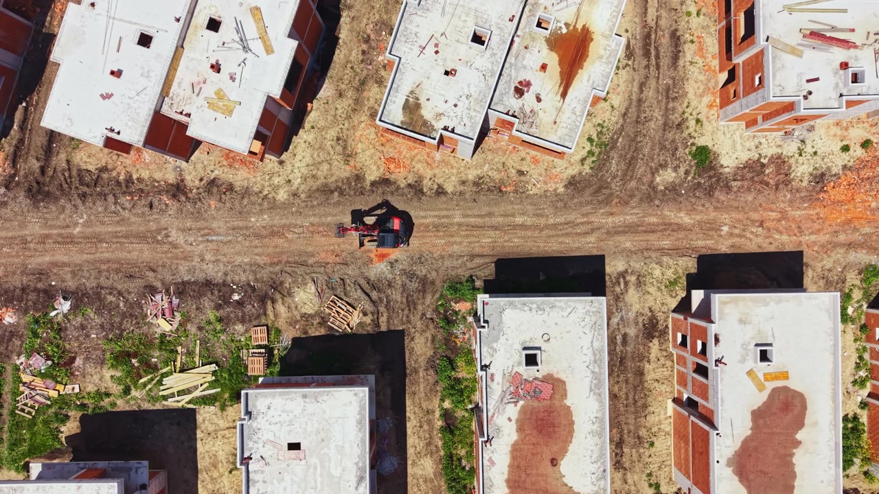 Canteiro de obras em andamento com máquinas e edifícios inacabados em um dia claro em uma área urbana