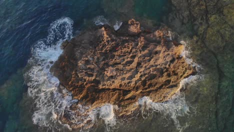 Olas-Golpeando-Rocas-Contra-Una-Pequeña-Isla-En-El-Océano