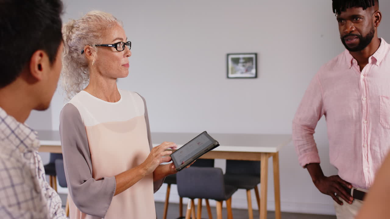 Business meeting, woman using tablet and discussing project with colleagues