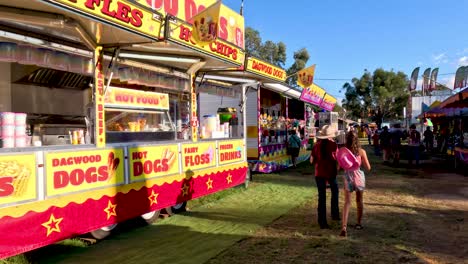 two girls walking past festival food stalls