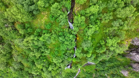 birds eye aerial view of picturesque waterfall and green hill and cliffs