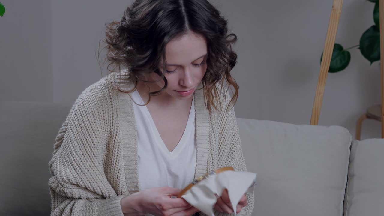 Giovane donna felice che cuce nel comfort del suo appartamento
