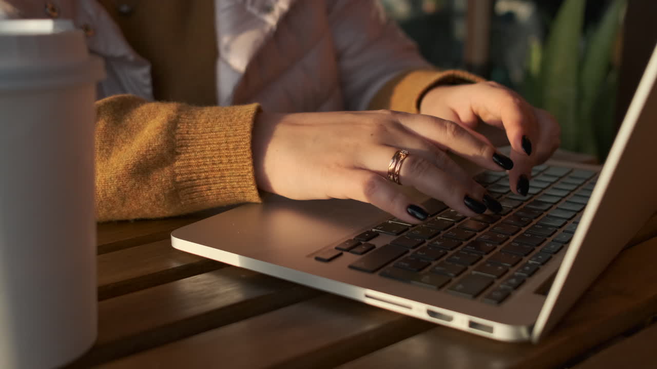 mujer trabajando en una computadora portátil en un café