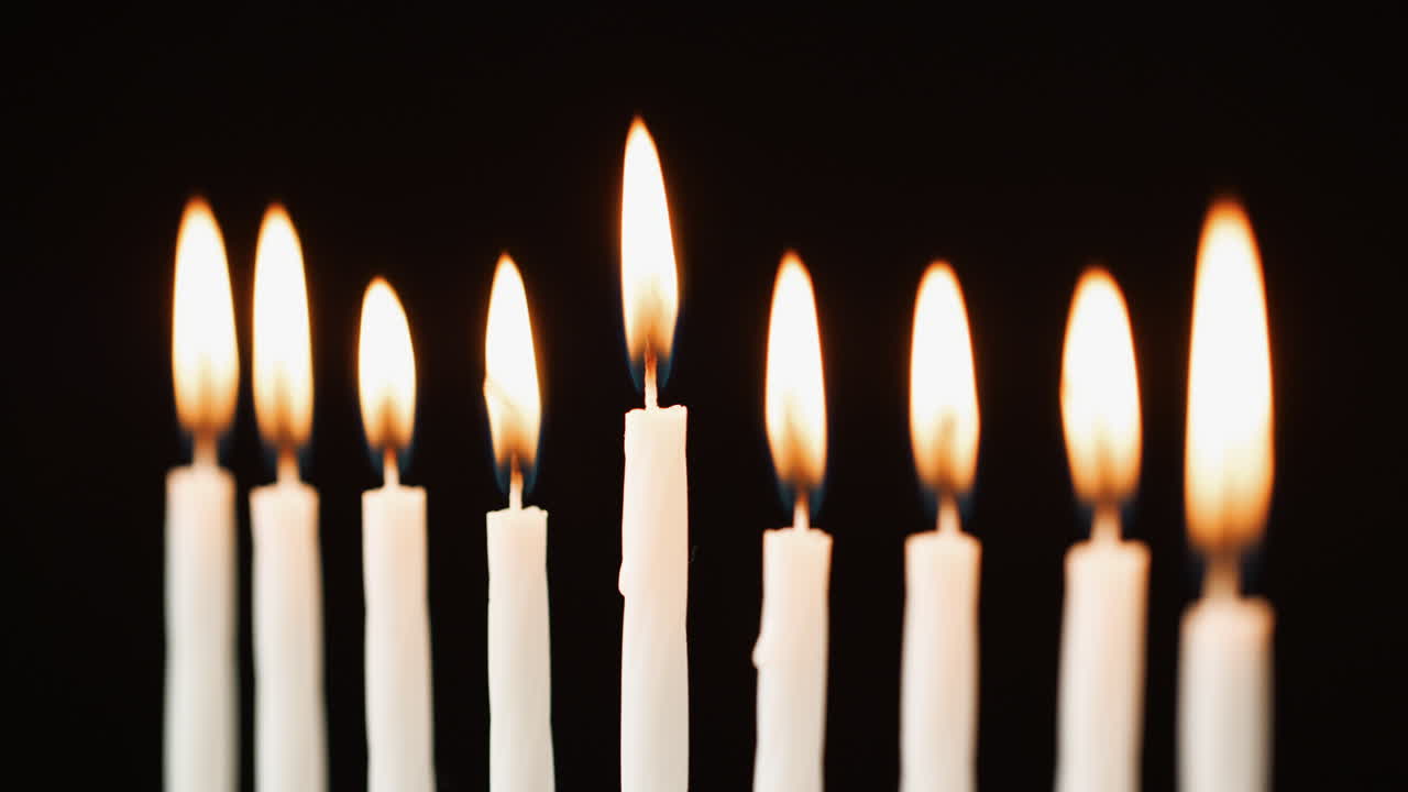 Primo piano di nove candele accese per la festa ebraica di Hanukkah, messa a fuoco selettiva