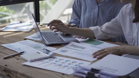 happy asian business woman team meeting brainstorm coworkers project finance graph document work together strategic planning for success enjoy working as a team in the office.