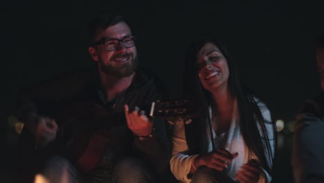 amigos felices divirtiéndose junto a la fogata.
