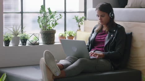 young hispanic business woman using laptop computer student working on project studying typing email messages browsing online networking enjoying listening to music in relaxed office workplace