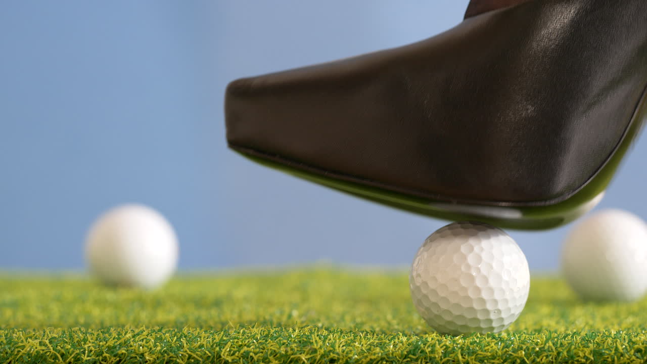 mujer coloca una pelota de golf en posición con sus zapatos de tacón alto