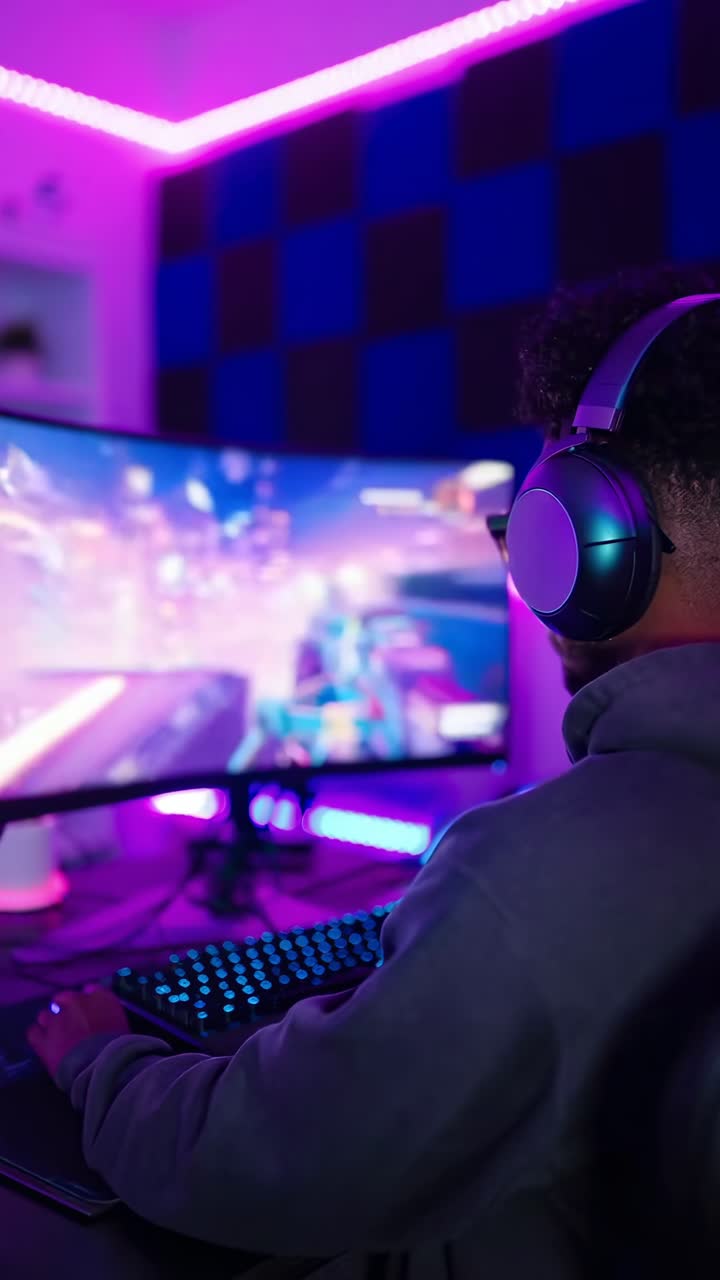 Young Man Playing Video Game on Computer with Neon Lights