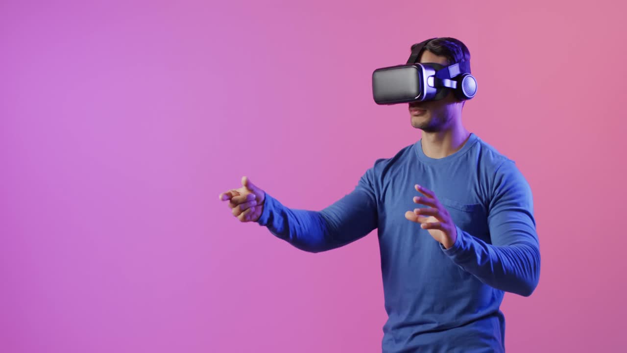 video di un uomo biraciale che usa le cuffie vr su sfondo rosa e viola