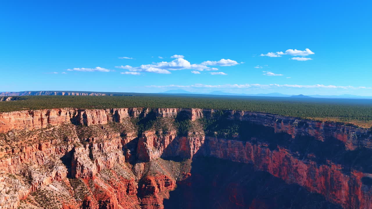 Stunning rocks in the Grand Canyon National Park, Arizona, USA. Greenery covering the plain and blue sky at backdrop