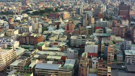 Aerial-view-drone-reverse-flyover-capturing-a-bustling-urban-landscape-in-Douliu-City,-Yunlin-County,-Taiwan,-downtown-cityscape-featuring-densely-packed-buildings,-narrow-streets