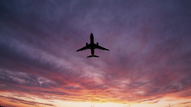 Commercial Airplane Flying Against a Vibrant Sunset Sky