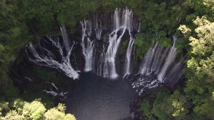 Un sorvolo su una bellissima cascata la cui acqua sgorga direttamente dalla roccia della montagna.