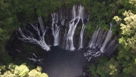 a fly over a beautiful waterfall which water come straight out of the rock of the mountain