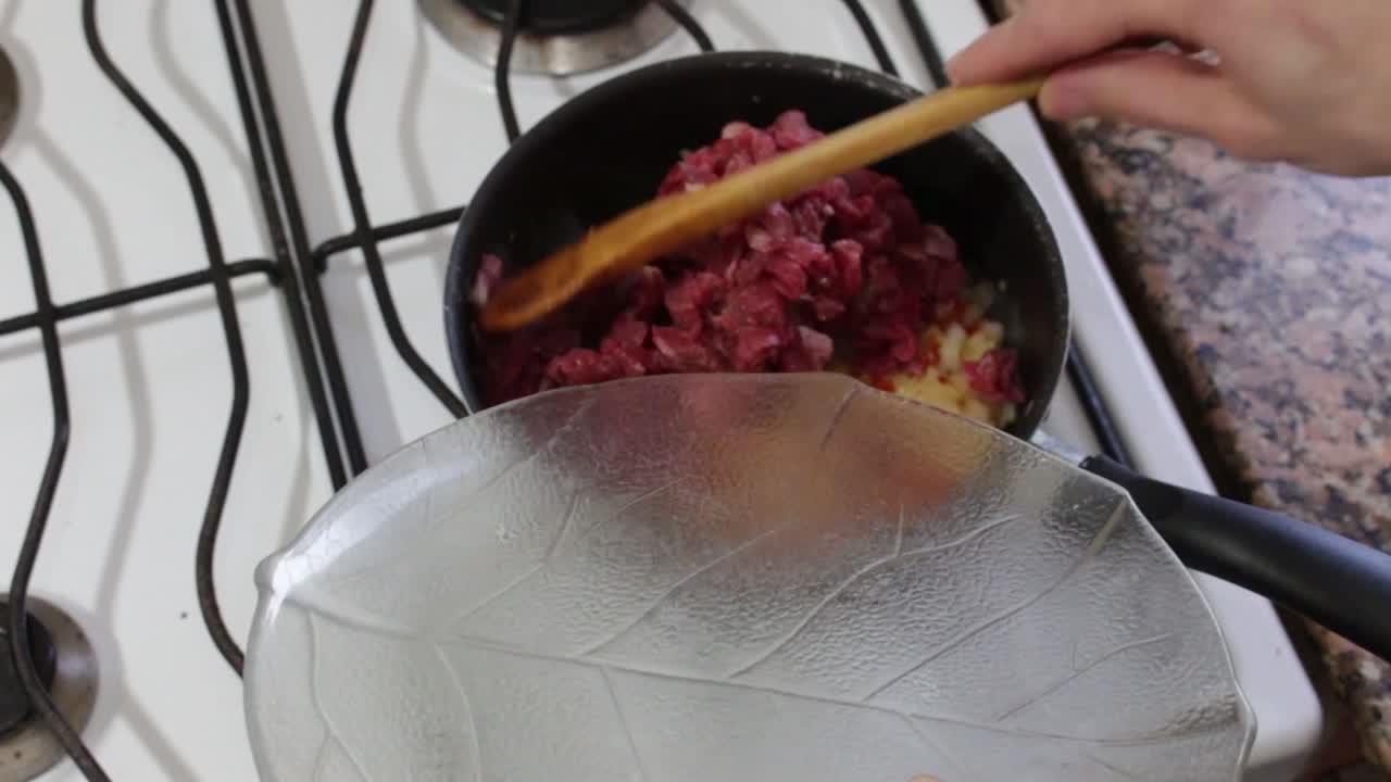 Static shot of cooking with chopped meat